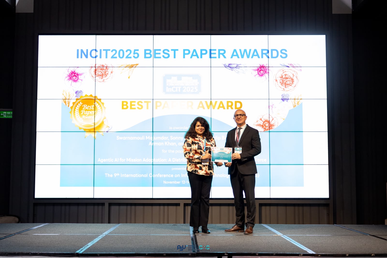 Swarnamouli Majumdar accepting a Best Paper Award onstage at IncIT 2025.