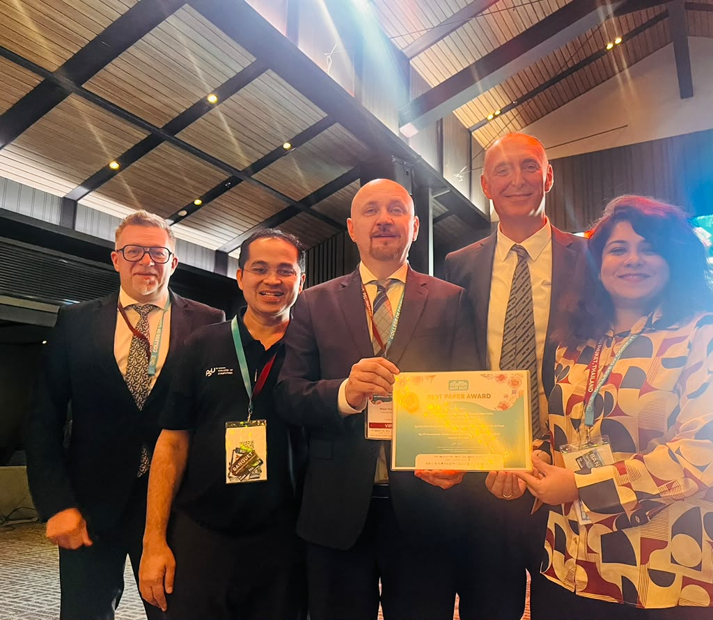 Swarnamouli Majumdar with conference organizers and researchers holding the IncIT 2025 Best Paper award.