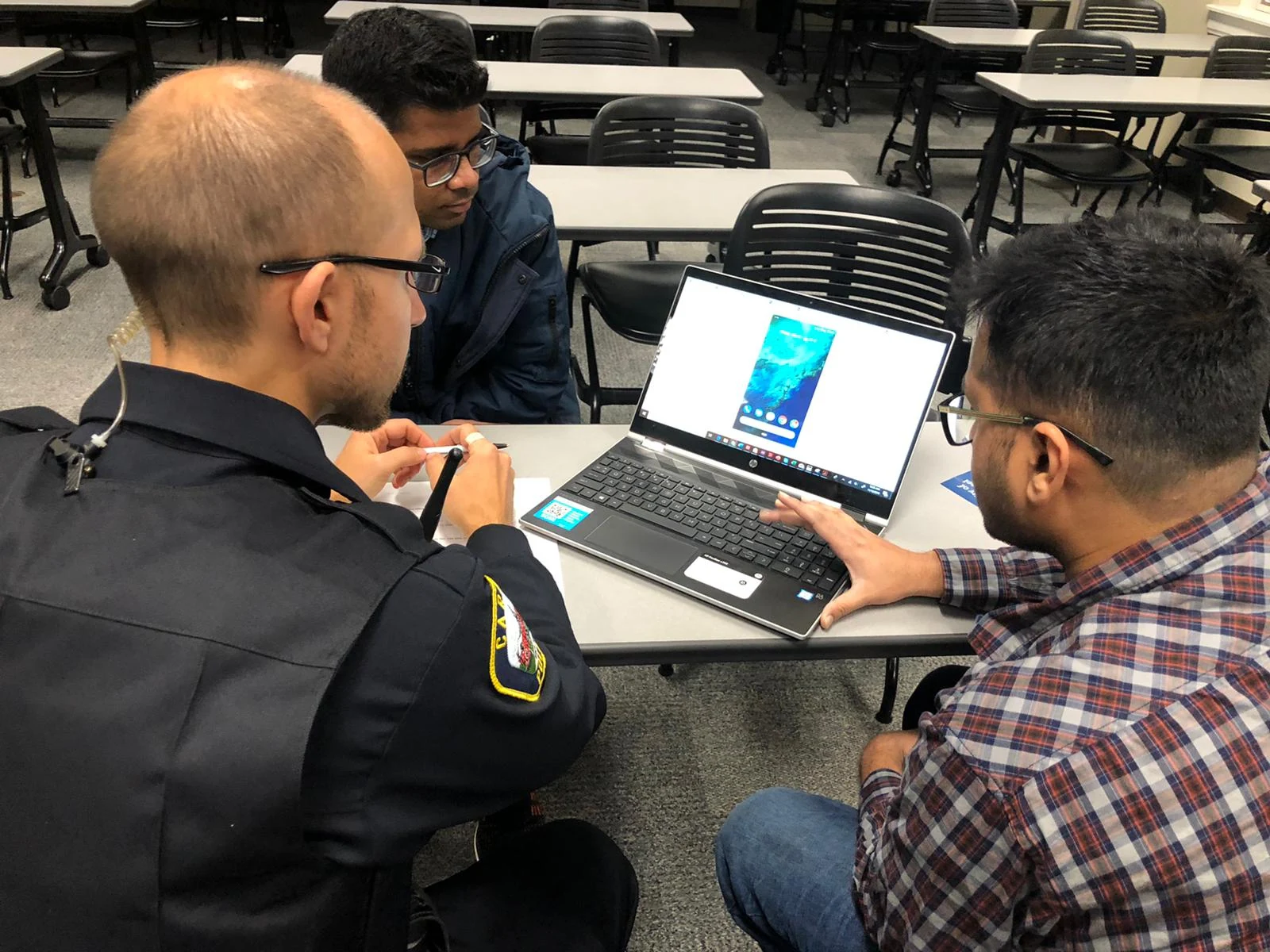 A public-safety professional reviewing a mobile prototype with Zenext researchers.